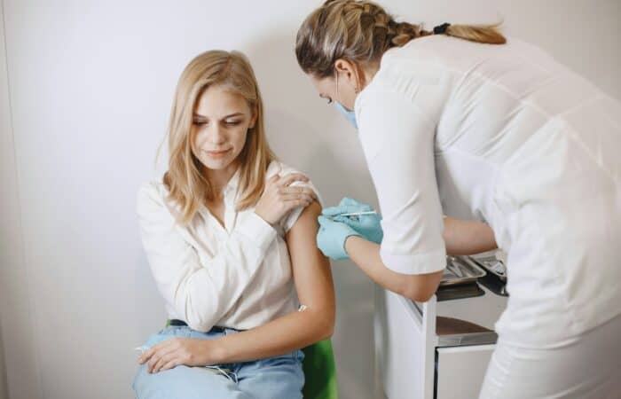 Woman doctor gives a vaccine to patients